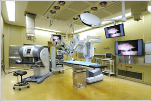 「ダヴィンチ サージカルシステム」は、手術器具を取り付けるロボットアームからなる「サージカルカート」（中央）、術者が手術操作する「サージョンコンソール」（左）、助手用モニターの「ヴィジョンカート」（中央奥）で構成される